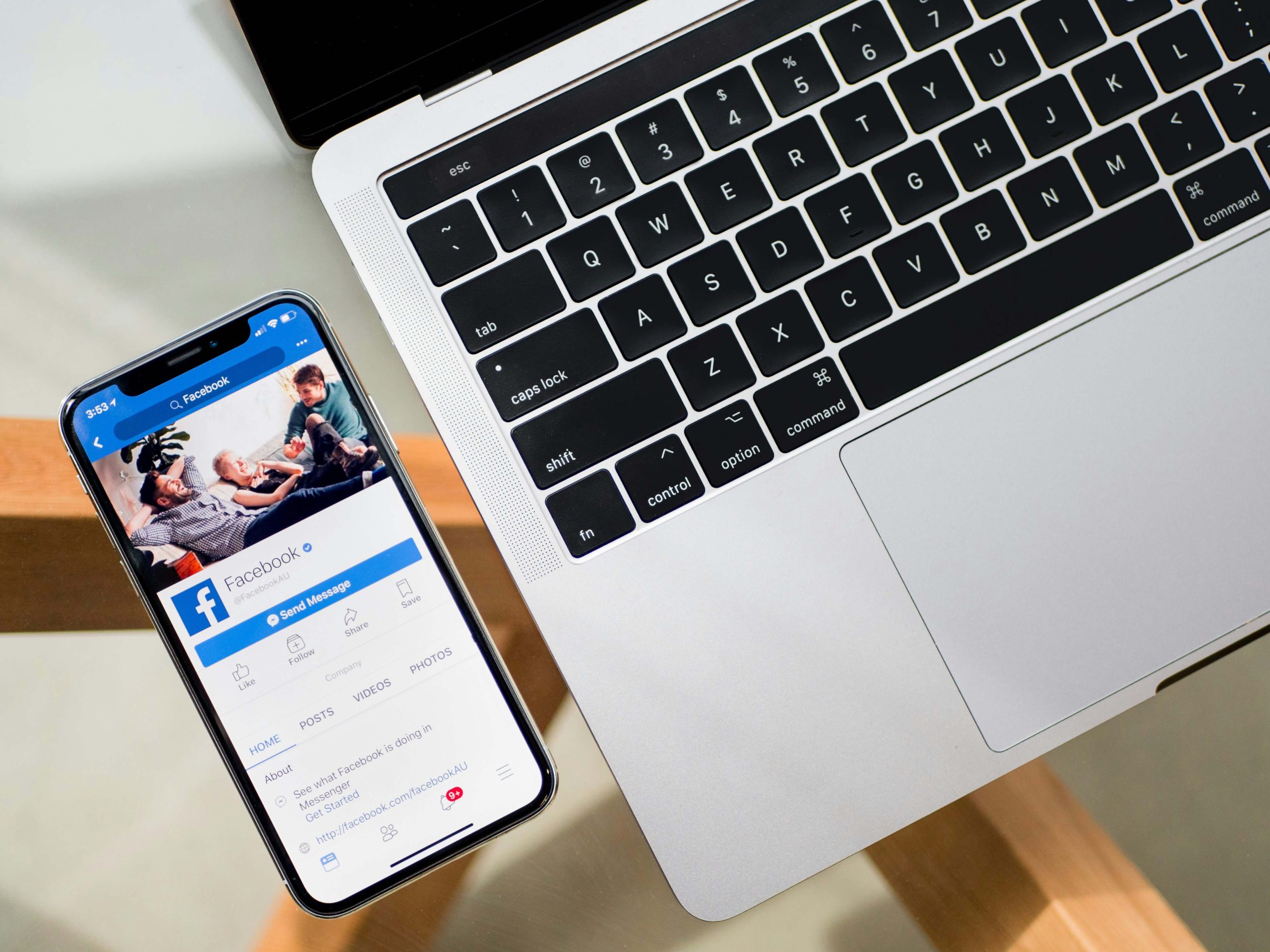 Phone open to Facebook next to laptop